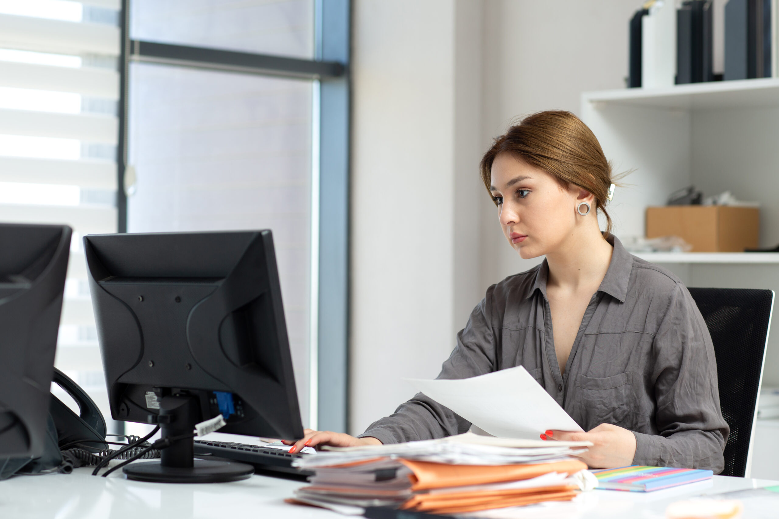 front-view-young-beautiful-lady-grey-shirt-working-with-documents-laptop-sitting-inside-her-office-during-daytime-building-job-activity - Mance Auto Finance
