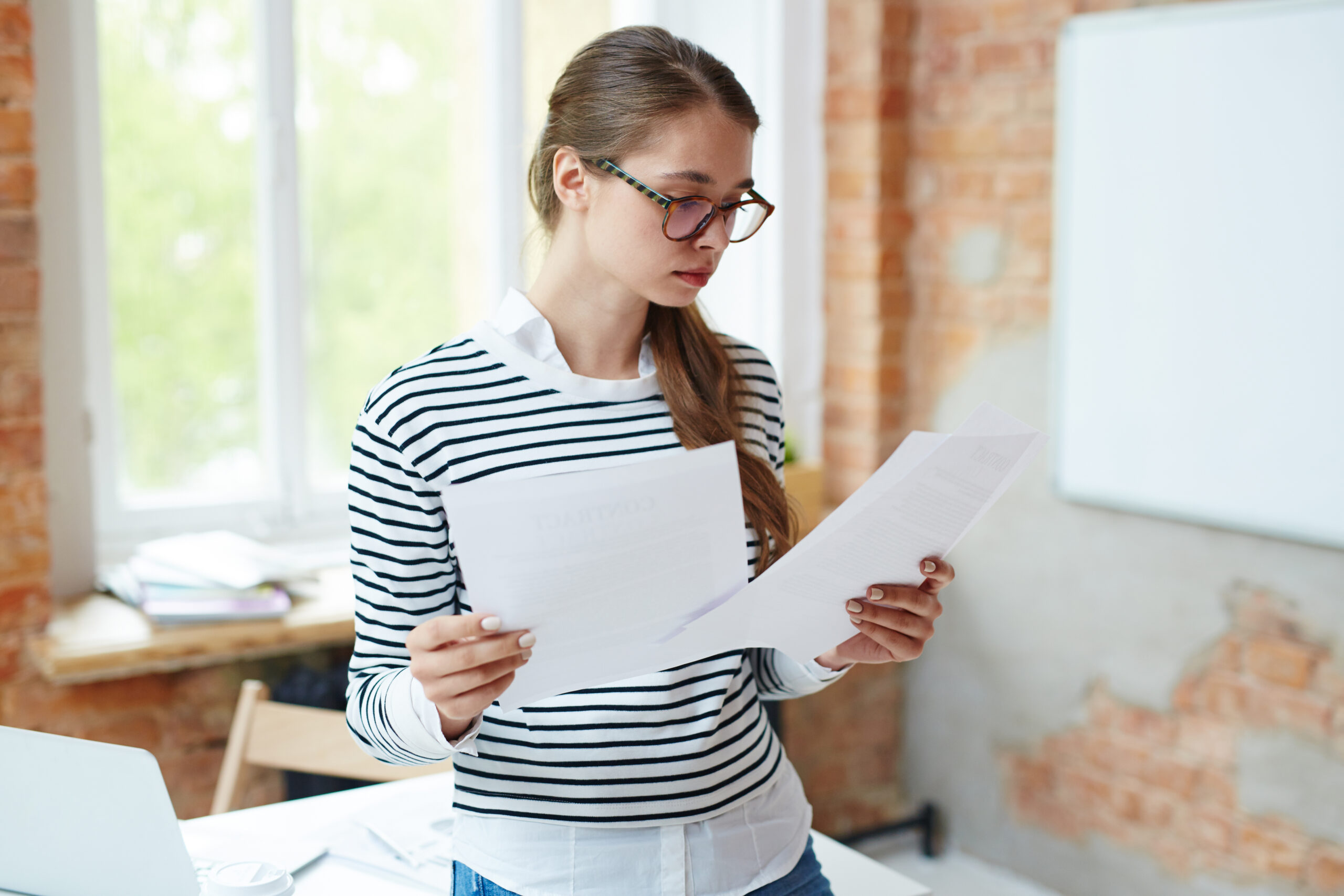Girl reading papers - Mance Auto Finance